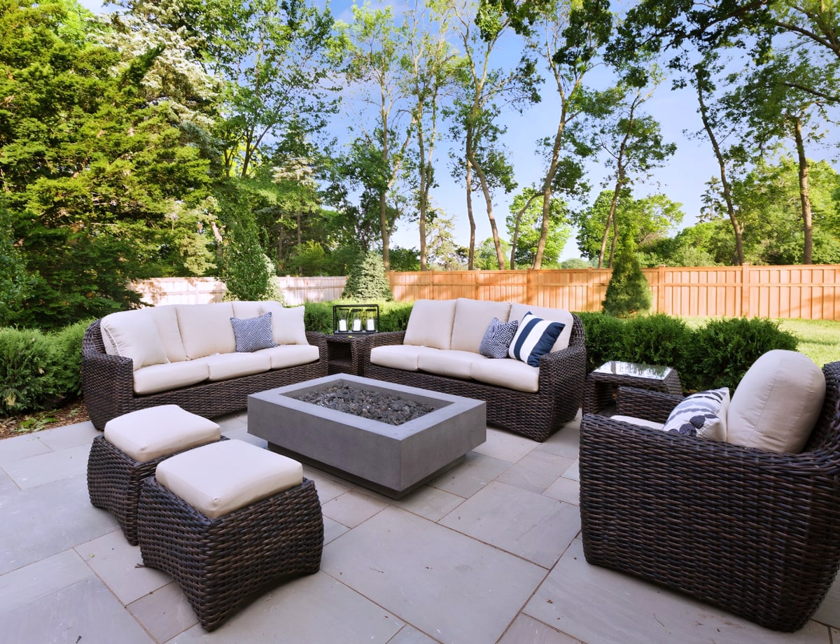 Patio with wicker sofas, fire pit table and stone pavers